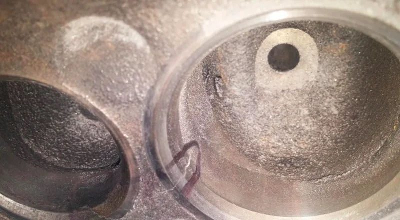 A crack in the cylinder head can lead to coolant consumption with no obvious signs of leakage (cracks are circled in the picture).
